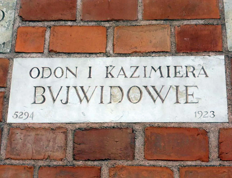 Tablica na ceglanej ścianie z napisem „ Odon i Kazimiera Bujwidowie”