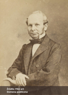 Fotografia portretowa w sepii mężczyzny ubranego elegancko,  Na dole zdjęcia podpis Źródło: PAU art oraz Domena publiczna. 
