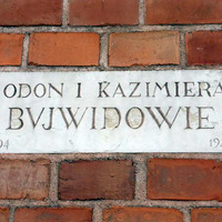Tablica na ceglanej ścianie  z napisem „ Odon i Kazimiera Bujwidowie”