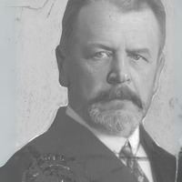 Czarno-biała fotografia portretowa mężczyzny z wąsami i brodą, ubranego elegancko.  Na dole zdjęcia podpis Źródło: Narodowe Archiwum Cyfrowe oraz Domena publiczna. 