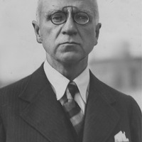 Fotografia czarno-biała przedstawiająca portret mężczyzny z okularami, ubranego elegancko. Na dole zdjęcia napis "Źródło: Narodowe Archiwum Cyfrowe oraz Domena publiczna".