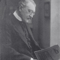 Fotografia czarno-biała przedstawiająca portret mężczyzny w okularach z wąsami i brodą, ubranego elegancko. Mężczyzna czyta gazetę. Na dole zdjęcia napis "Źródło: Katedra Historii Medycyny oraz CC-BY-NC".